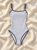 White navy dot one piece flat lay